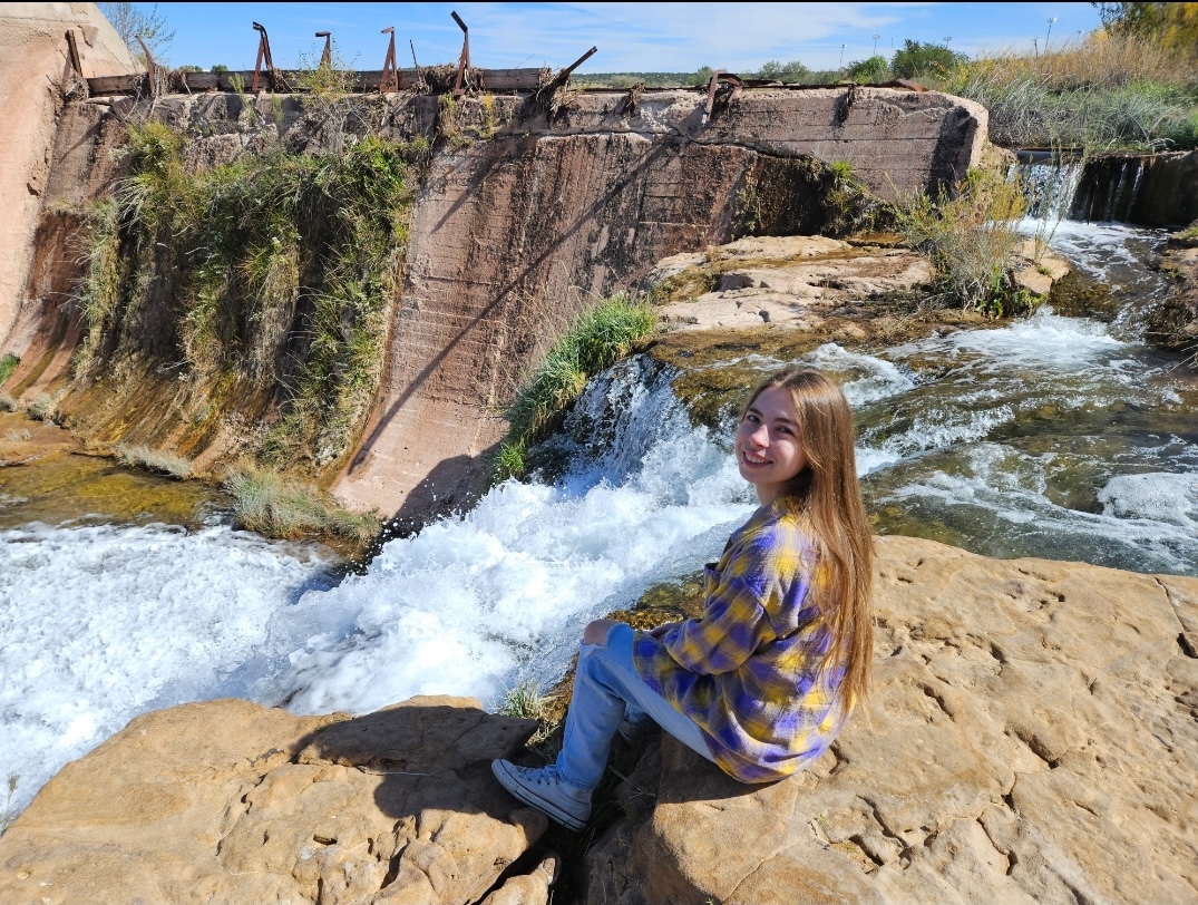 Zoe Bosin seated beside a waterfall